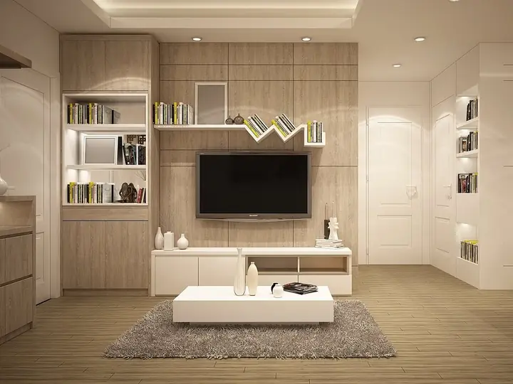 Phòng khách ốp gỗ sáng màu, có tivi và kệ sách